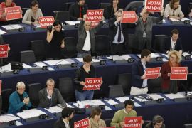 Members of the Confederal Group of the European United Left of the European Parliament hold posters as they take part in a voting session on a motion of censure of the European Commission at the European Parliament in Strasbourg, November 27, 2014. The signs read "No tax heaven", "No to austerity", "No to far right hypocrisy". REUTERS/Vincent Kessler (FRANCE - Tags: POLITICS BUSINESS)