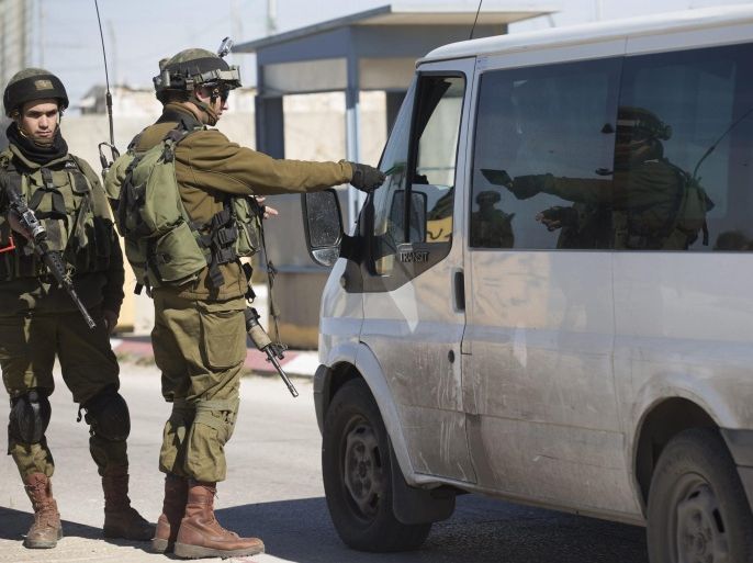 Israeli soldiers check identity cards of Palestinians on their way out of the west Bank town of Ramallah, at the checkpoint of Atara, 01 February 2016. Reports state Israeli army imposed restriction on the movement of Palestinians from and into Ramallah, one day after a shooting attack against Israeli soldiers guarding a central West Bank checkpoint between Ramallah and the Jewish settlement of Beit El.