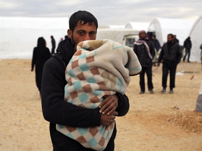 In this photo provided by Turkish Islamic aid group IHH, Syrians gather at a temporary refugee camp for displaced Syrians in northern Syria, near Bab al-Salameh border crossing with Turkey, Sunday, Feb. 7, 2016. Turkey is facing mounting pressure to open its border as tens of thousands of Syrian fleeing a government onslaught and intense Russian airstrikes arrived at the frontier. (IHH via AP)