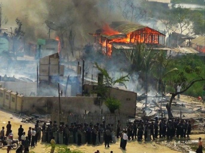 مشهد يعود لعام 2012م يظهر إحراق البوذيين لمنازل الروهينغا بينما يصطف العسكر الميانماري متفرجاً- مجلة الجزيرة