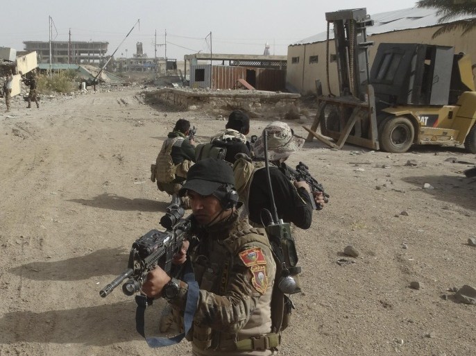 In this Tuesday, Jan. 19, 2016 photo, Iraqi security forces clear central Ramadi of Islamic State fighters, 70 miles (115 kilometers) west of Baghdad, Iraq. The Islamic State group, which controls large parts of Syria and Iraq where it declared an Islamic caliphate in June 2014, suffered several defeats recently in both countries, including the loss of the Iraqi city of Ramadi and parts of northern and northeastern Syria over the past months. (AP Photo)