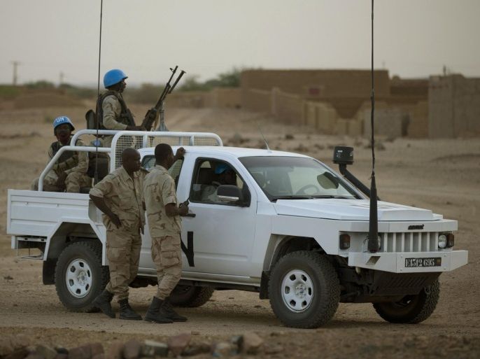 In this July 28, 2013 photo, United Nations peacekeepers stand guard at a polling station, during presidential elections in Kidal, Mali. A bomb explosion killed several members of the U.N. peacekeeping mission in Mali in the troubled northern city of Kidal, a spokesman for the mission said Saturday, Dec. 14, 2013. (AP Photo/Rebecca Blackwell)