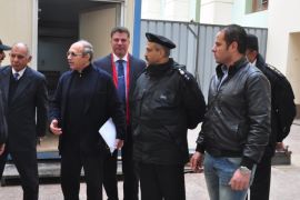 Former Egyptian Interior Minister Habib el-Adly, center, talks to police outside of a courtroom in Cairo, Egypt, Tuesday, Feb. 24, 2015 after he and former Prime Minister Ahmed Nazif were acquitted in a corruption case. The MEAN news agency says the Cairo Criminal Court made the ruling Tuesday in the retrial of Nazif and el-Adly, both of whom served in Hosni Mubarak's Cabinet before the Jan. 25, 2011, uprising that eventually forced Mubarak out of power. The two men faced charges of squandering public money. (AP Photo/Mohammed al-Law)