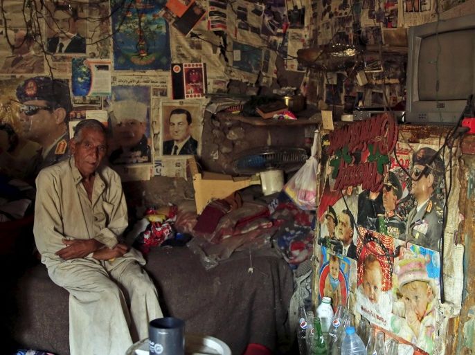 67-year-old El Hag Sayed poses for a photograph in his self-built house, which is decorated with pictures of Egyptian President Abdel Fattah al-Sisi and ousted president Hosni Mubarak, in the Eshash el-Sudan slum in the Dokki neighbourhood of Giza, south of Cairo, Egypt September 2, 2015. Residents of the slum clashed with police in late August, when about 50 ramshackle huts were destroyed and at least 20 people were injured by teargas, local media reported, as authorities attempt to clear the area and rehouse residents. The slum dwellers, some of whom have called Eshash el-Sudan home for 50 years, say there are not enough apartments built nearby to house them. The residents of the slum eke out a living by disposing of rubbish or baking bread. Schooling is too expensive for most of their children, who play with salvaged rubbish amid shacks made out of discarded wood and leather. REUTERS/Amr Abdallah DalshSEARCH "ESHASH EL-SUDAN" FOR ALL PICTURES