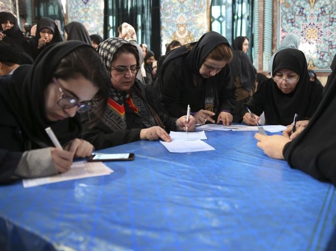 Iranian voters fill out their ballots during the country's parliamentary and Experts Assembly elections in a polling station in northern Tehran, Iran, Friday, Feb. 26, 2016. Iranians were voting on Friday in parliamentary elections, the country's first since its landmark nuclear deal with world powers last summer. At the same time as parliamentary elections, Iranians are also voting for the Assembly of Experts, a clerical body empowered to choose or dismiss the country's supreme leader. (AP Photo/Vahid Salemi)