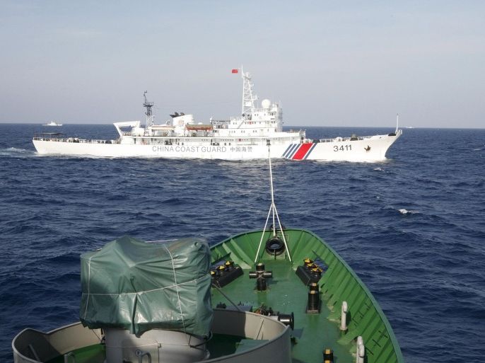 A Chinese Coast Guard ship (top) is seen near a Vietnam Marine Guard ship in the South China Sea, about 210 km (130 miles) off shore of Vietnam, in this May 14, 2014 file photo. From listening posts to jet fighter deployments and now surface-to-air missiles, China's expanding facilities in the Paracel Islands are a signal of long-term plans to strengthen its military reach across the disputed South China Sea. REUTERS/Nguyen Minh/Files