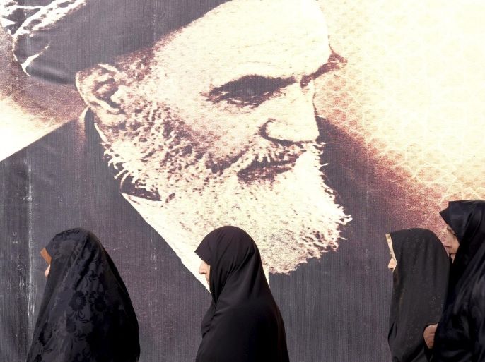 Iranian women walk past a poster of Iran's late leader Ayatollah Ruhollah Khomeini during the anniversary ceremony of Iran's Islamic Revolution in Behesht Zahra cemetery, south of Tehran, February 1, 2016. REUTERS/Raheb Homavandi/TIMA ATTENTION EDITORS - THIS IMAGE WAS PROVIDED BY A THIRD PARTY. FOR EDITORIAL USE ONLY.