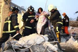 Rescue personnel help a victim at a damaged building after an earthquake in Tainan, southern Taiwan, February 6, 2016. REUTERS/Stringer TAIWAN OUT. NO COMMERCIAL OR EDITORIAL SALES IN TAIWAN. EDITORIAL USE ONLY. NO RESALES. NO ARCHIVE. TPX IMAGES OF THE DAY
