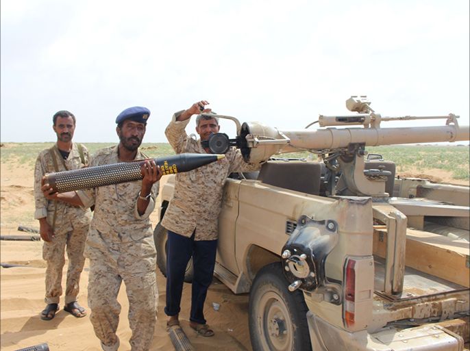أفراد من الجيش الوطني يطلقون قذائف المدفعية على مواقع للحوثيين في ميدي تمهيدا للهجوم