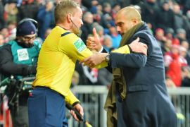 Munich head coach Pep Guardiola, right, congratulates the assistant referee during the soccer match between FC Bayern Munich and FC Schalke in the Allianz Arena in Munich, Germany, on Tuesday, Feb. 3, 2015. (AP Photo/Kerstin Joensson)