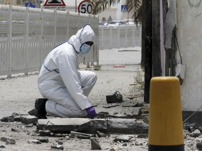 An explosives specialist police officer conducts an investigation after a bomb blast in the village of Sitra, south of Manama, Bahrain, July 28, 2015. The bomb attack killed two Bahraini policemen on duty in the mainly Shi'ite village of Sitra, south of the capital Manama, the Interior Ministry said on Tuesday, days after the government said it had disrupted an arms smuggling plot linked to Iran. REUTERS/Hamad I Mohammed