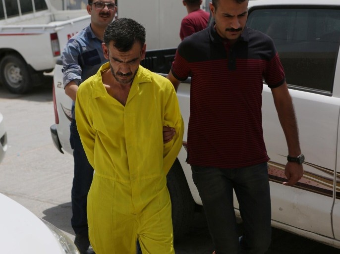 Adnan Abdul Redha, a suspected member with the Islamic State group, is escorted at the federal police headquarters in Basra, 340 miles (550 kilometers) southeast of Baghdad, Iraq, Tuesday, July 21, 2015. Iraqi special operations commandos arrested Abdul Redha during recent security operations in Basra and accuses him of participating the massacre in Camp Speicher military base, the Iraqi government believes hundreds, possibly thousands, were buried in low graves after the Islamic State group captured Tikrit. (AP Photo/Nabil al-Jurani)