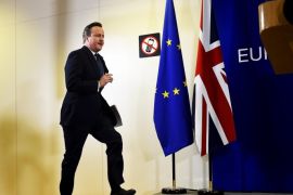 British Prime Minister David Cameron jumps up on stage as he prepares to address the media after a European Union leaders' summit in Brussels, Belgium, February 19, 2016. Cameron said on Friday he would campaign with all his "heart and soul" for Britain to stay in the European Union after he won a deal about the so-called Brexit, in Brussels which offered his country "special status". REUTERS/Dylan Martinez
