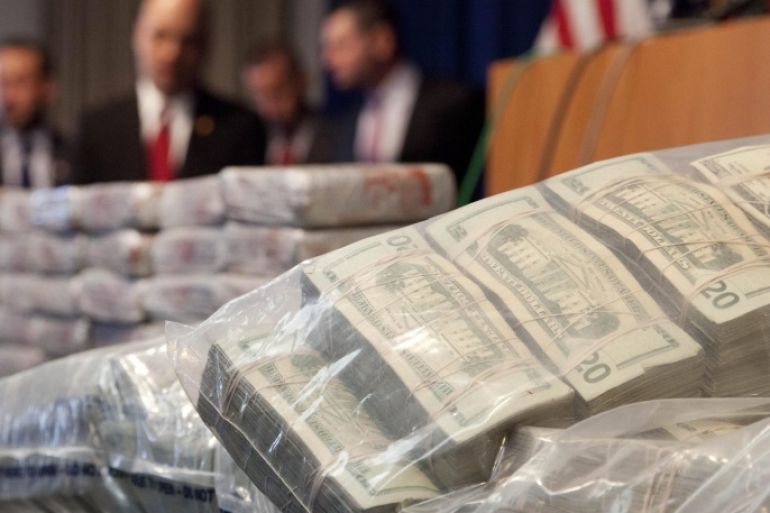 Sacks of money, right, worth $2 million, and 154 pounds of heroin, left, worth at least $50 million, are displayed at a Drug Enforcement Administration news conference, Tuesday, May 19, 2015 in New York. The DEA called the heroin seizure its largest ever in New York state. Officials said on Tuesday that most of the drugs were found in an SUV in the Bronx following a wiretap investigation. (AP Photo/Mark Lennihan)