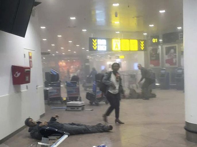 In this photo provided by Georgian Public Broadcaster and photographed by Ketevan Kardava a man is wounded in Brussels Airport in Brussels, Belgium, after explosions were heard Tuesday, March 22, 2016. A developing situation left a number dead in explosions that ripped through the departure hall at Brussels airport Tuesday, police said. All flights were canceled, arriving planes were being diverted and Belgium's terror alert level was raised to maximum, officials said. (Ketevan Kardava/ Georgian Public Broadcaster via AP)