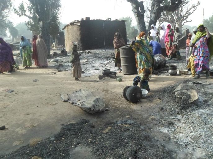 Women and children look at burnt out houses following an attack by Boko Haram in Dalori village 5 kilometers (3 miles) from Maiduguri, Nigeria, Sunday Jan. 31, 2016. A survivor hidden in a tree says he watched Boko Haram extremists firebomb huts and listened to the screams of children among people burned to death in the latest attack by Nigeria’ s homegrown Islamic extremists. (AP Photo/Jossy Ola)