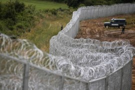 Bulgarian border police stand near a barbed wire fence on the Bulgarian-Turkish border July 17, 2014. Bulgaria started the construction of a fence on the border with its southeastern neighbour Turkey since January as the EU's poorest country attempts to cope with a soaring number of asylum seekers and refugees mainly from Syrian. REUTERS/Stoyan Nenov (BULGARIA - Tags: POLITICS SOCIETY MILITARY IMMIGRATION)