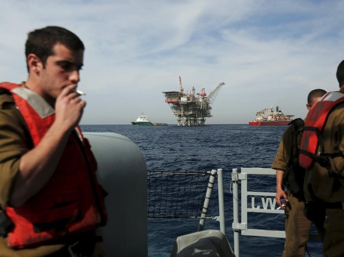 Sailors in Israel's navy smoke cigarettes aboard a patrol boat near an Israeli gas platform, controlled by a U.S.-Israeli energy group Noble and Delek, in the Mediterranean sea, some 15 miles (24 km) west of the port city of Ashdod, in this file picture taken February 25, 2013. Israel's security cabinet on June 25, 2015 is expected to vote in favour of a plan that will allow the U.S.-Israeli energy group to keep control over most of the country's natural gas deposits but will also put some others up for sale. The decision will end months of uncertainty and would be welcomed by Texas-based Noble Energy and Israel's Delek Group. REUTERS/Amir Cohen/Files