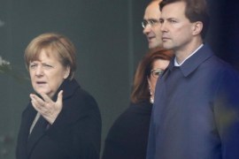 German Chancellor Angela Merkel (L) reacts as she talks to German government spokesman Steffen Seibert (R) while waiting for the arrival of Algeria's Prime Minister Abdelmalek Sellal at the Chancellery in Berlin, Germany, January 12, 2016. Picture taken through a window. REUTERS/Fabrizio Bensch