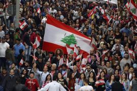 Lebanese activists from the 'You Stink' movement and other civil democratic movements wave their national flag and carry placards as they walk during a protest against the ongoing garbage crisis in front of the Lebanese government palace, downtown Beirut, Lebanon, 12 March 2016. The protesters demanded solutions for the ongoing garbage crisis, and abolition of corruption and accounting the corrupt.