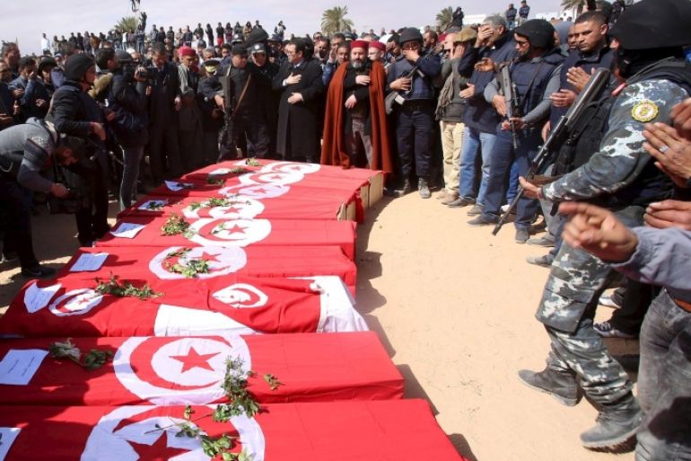 Mourners stand near the flag-draped coffins of soldiers and civilians who were killed during Monday's attack on army and police posts by Islamist fighters in the town of Ben Guerdan, Tunisia, near the Libyan border March 9, 2016. REUTERS/Zoubeir Souissi
