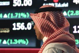 FILE - In this June 15, 2015, file photo, a Saudi man looks at the trading board at the Tadawul Saudi Stock Exchange, in Riyadh, Saudi Arabia. Within hours of ascending to the Saudi throne, King Salman announced sweeping changes that would recast the kingdom’s line of succession, and rework its security and economic decision-making processes. It marked the start of what would be a tumultuous year for King Salman, who completes one year as monarch on Saturday, Jan. 23, 2016. (AP Photo/Hasan Jamali, File)