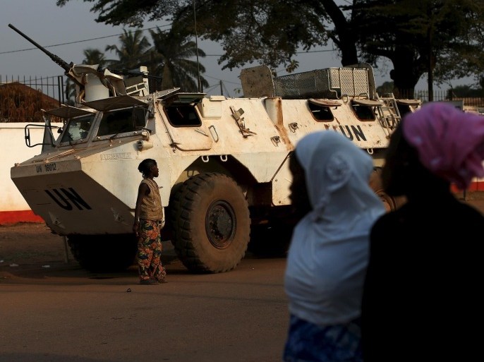 Women walk by a United Nations peacekeeping armoured vehicle guarding the outer perimeter of a compound of a school used as an electoral centre at the end of the presidential and legislative elections, in the mostly muslim PK5 neighbourhood of Bangui, Central African Republic, February 14, 2016. REUTERS/Siegfried Modola