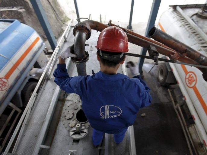 An employee fills the tank of a petrol delivery vehicle at a Sinopec refinery in Wuhan, Hubei province, in this April 25, 2012 file photo. China's emergence as a major oil product exporter is depressing oil refining margins across Asia as favourable domestic fuel policies encourage Chinese refiners to keep output high and flood regional markets with surplus supplies. REUTERS/Stringer/Files CHINA OUT. NO COMMERCIAL OR EDITORIAL SALES IN CHINA.
