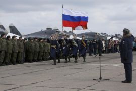 In this photo provided by the Russian Defense Ministry Press Service, guards walk past a lineup of troops during a welcome ceremony for Russian military personnel who returned from Syria at an airbase near the Russian city Voronezh, Tuesday, March 15, 2016. Russian warplanes and troops stationed at Russia's air base in Syria started leaving for home on Tuesday after a partial pullout order from President Vladimir Putin the previous day, a step that raises hopes for progress at the newly reconvened U.N.-brokered peace talks in Geneva. (Russian Defense Ministry Press Service via AP)