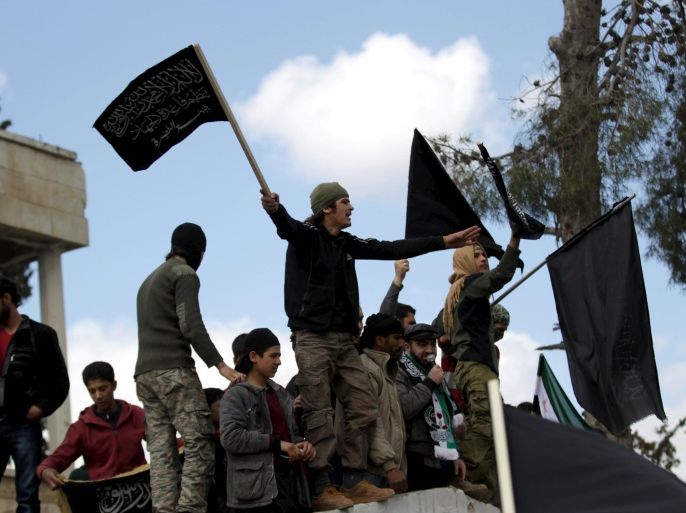 Protesters carry Nusra Front flags and shout slogans during an anti-government protest after Friday prayers in the town of Marat Numan in Idlib province, Syria, March 11, 2016. REUTERS/Khalil Ashawi