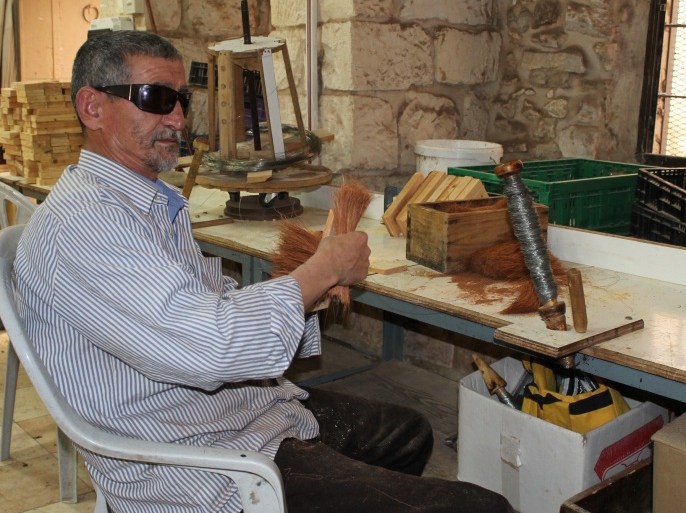 أبو حسن محمود حسن طه كفيف يصنع المكانس في جمعية المكفوفين في القدس