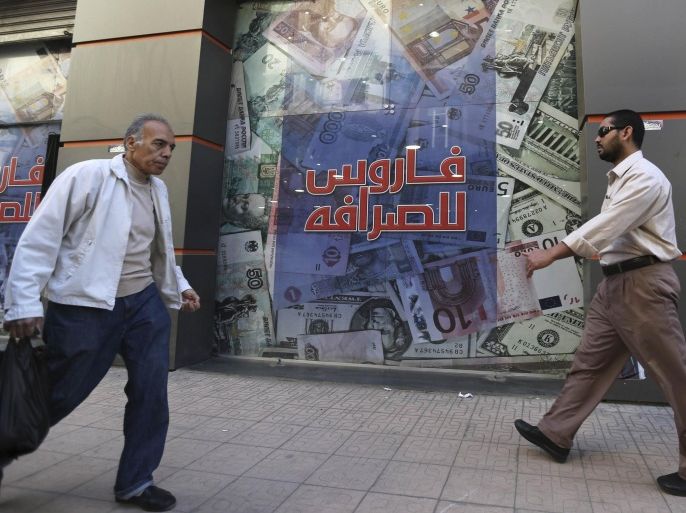 People walks outside an exchange bureau in Cairo , March 12, 2015. After four years of political turmoil, Egypt is staking its economic revival on an investment summit in Sharm el-Sheikh it hopes will burnish its image and attract billions of dollars. REUTERS/Mohamed Abd El Ghany (EGYPT - Tags: POLITICS BUSINESS)