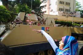 متظاهرة تلقي بالورود على قوات الجيش التي تمركزت بالميادين في أعقاب انقلاب الثالث من يوليو/تموز2013 . ( تصوير خاص ـ من أمام مديرية أمن الجيزة ـ القاهرة ـ يوليو 2013