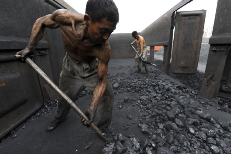 Workers unload coal at a storage site along a railway station in Hefei, Anhui province, in this October 27, 2009 file photo. China expects to lay off 1.8 million workers in the coal and steel sectors as part of its efforts to reduce industrial overcapacity, an official at the human resources and social security ministry said on February 29, 2016. REUTERS/Jianan Yu/Files