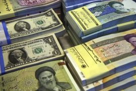 FILE--In this Saturday, April 4, 2015 file photo, Iranian and U.S. banknotes are on display at a currency exchange shop in downtown Tehran, Iran. Iran said Tuesday, Jan. 19, 2016, it successfully transferred some of the billions of dollars' worth of frozen overseas assets following the implementation of the nuclear deal with world powers. But ordinary Iranians are still waiting to see how their daily lives will improve and how fast Iranian companies will gain access to financial markets worldwide. (AP Photo/Vahid Salemi,File)
