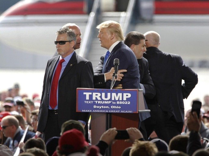 Security personnel surround Republican presidential candidate Donald Trump after a man tried to rush the stage during a rally in Vandalia, Ohio, outside of Dayton, on Saturday, March 12, 2016. The man was stopped and Trump continued with his speech. (Lisa Powell/The Dayton Daily News via AP) LOCAL PRINT OUT; LOCAL TELEVISION OUT; WKEF-TV OUT; WRGT-TV OUT; WDTN-TV OUT; MANDATORY CREDIT