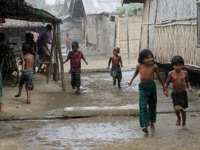 Rohingya children play during rain at an Internally Displaced Persons (IDPs) camp near Sittwe of Rakhine State, western Myanmar, 22 March 2016. According to media reports, the US State Department said on 21 March 2016 that Myanmar is persecuting its Rohingya Muslims, but not at the level of genocide.
