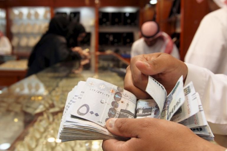 A salesman counts money at a jewellery shop at the gold market in Riyadh, in this March 11, 2013 file photo. The private sector in the two biggest Gulf Arab economies grew at the slowest pace in years in October, corporate surveys showed on November 3, 2015, indicating low oil prices are starting to slow business activity across the region. REUTERS/Stringer/Files