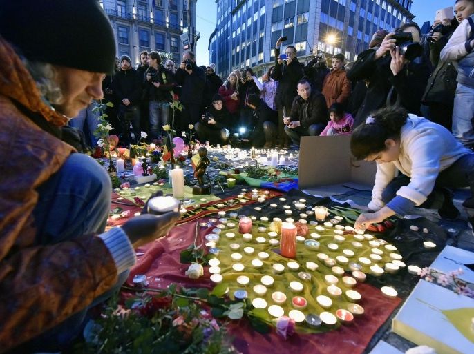 People bring flowers and candles to mourn for the victims at Place de la Bourse in the center of Brussels, Tuesday, March 22, 2016. Bombs exploded at the Brussels airport and one of the city's metro stations Tuesday, killing and wounding scores of people, as a European capital was again locked down amid heightened security threats. (AP Photo/Martin Meissner)