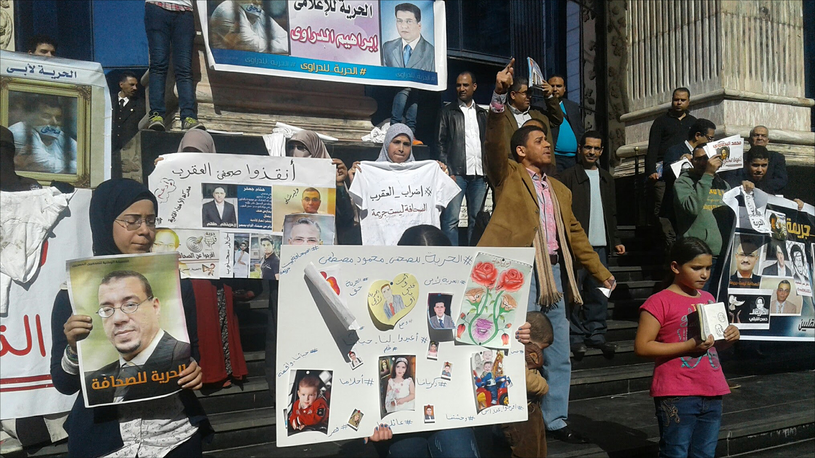 وقفة لأسر الصحفيين المعتقلين على سلم نقابة الصحفيين للمطالبة بالإفراج عنهم (الجزيرة)