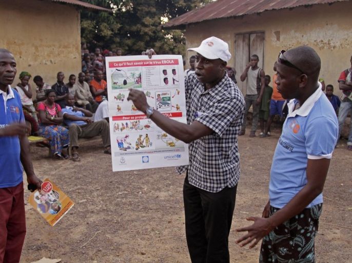 In this photo taken Tuesday, Jan. 24, 2015, health workers provide education to people about the Ebola virus on prevention and general health tips in Conakry, Guinea. The World Health Organization says Thursday, March 12, 2015, its tally of Ebola deaths has passed the grim milestone of 10,000, mostly in West Africa. (AP Photo/ Youssouf Bah)