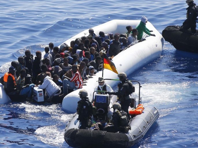 In this March 29, 2016 picture German Navy sailors ad Finish Special Forces surround a boat with migrants near the German combat supply ship 'Frankfurt am Main' during EUNAVFOR MED Operation Sophia in the Mediterranean Sea off the coast of Libya . (AP Photo/Matthias Schrader)
