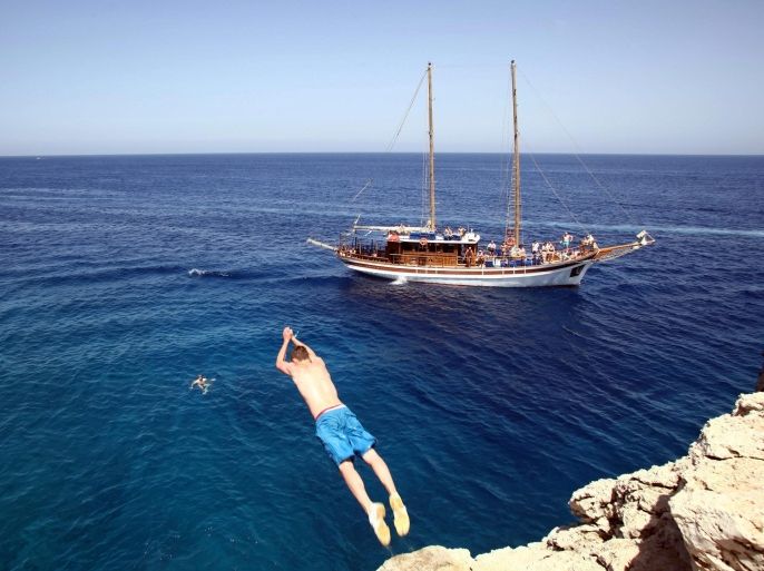 A boy jumps into the sea at Protaras on the south-east tip of Cyprus, 12 September 2014. According to data from the Statistical Office surpassed one million tourist arrivals in Cyprus the three months of May, June and July. All visitors reached 1,065,288, while only tourists was 1,017,357.