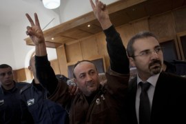 FILE - In this Wednesday, Jan. 25, 2012 file photo, senior Fatah leader Marwan Barghouti makes the victory sign in front of the media during his arrival to testify in a trial at a Jerusalem court. On Wednesday, Nov. 12, 2014, Barghouti, a Palestinian leader serving a life sentence in Israel for his role in the Palestinian uprising last decade, was sentenced to a week in solitary for calling for more violence and for the Palestinian Authority to stop its security cooperation with Israel. Israeli media interpreted that as a call for a third Intifada, or Palestinian uprising. (AP Photo/Bernat Armangue, File)