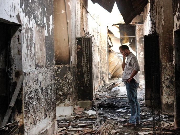 FILE - In this Oct. 16, 2015, file photo, an employee of Doctors Without Borders walks inside the charred remains of the organization's hospital after it was hit by a U.S. airstrike in Kunduz, Afghanistan. About 16 U.S. military personnel, including a two-star general, have been disciplined for mistakes that led to the bombing of the civilian hospital in Afghanistan last year that killed 42 people, a senior U.S. official said Thursday, April 28, 2016. According to officials, no criminal charges were filed and the service members received administrative punishments in connection with the U.S. air strike in the northern city of Kunduz. (AP Photo/Najim Rahim, File)