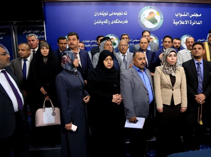 Members of parliament, who held a sit-in overnight inside the parliament building, stand during a news conference, in Baghdad, Iraq, Wednesday, April 13, 2016. For the second consecutive day, at least one hundred lawmakers from Shiite and Sunnis, have continued holding a sit-in inside the hall of meetings of the parliament, protesting at the postponement of vote on the technocrat cabinet. (AP Photo/Karim Kadim)