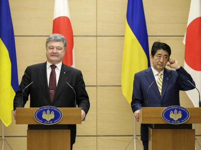 Ukrainian President Petro Poroshenko, left, accompanied by Japanese Prime Minister Shinzo Abe, speaks during a joint press conference following their meeting at the latter's official residence in Tokyo, Wednesday, April 6, 2016. Poroshenko was in Japan to meet Abe and business leaders. (Kimimasa Mayama/Pool Photo via AP)