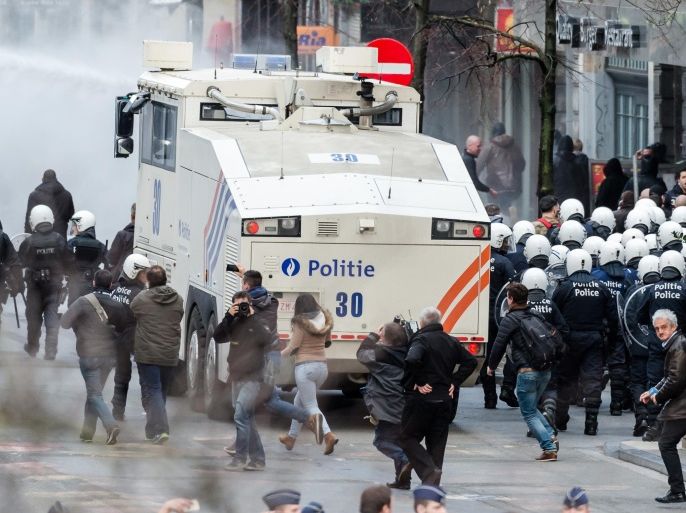 Police use a water canon as right wing demonstrators protest at a memorial site at the Place de la Bourse in Brussels, Sunday, March 27, 2016. In a sign of the tensions in the Belgian capital and the way security services are stretched across the country, Belgium's interior minister appealed to residents not to march Sunday in Brussels in solidarity with the victims. (AP Photo/Geert Vanden Wijngaert)