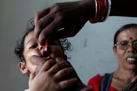 An Indian girl receives a polio vaccine drops by a government health worker at a recidence in eastern Indian city of Calcutta, 18 June 2013. The government health department launched a massive polio vaccine programme after finding a polio victim in Howrah District in Bengal last month. Two polio vaccines are used throughout the world to combat poliomyelitis or polio.