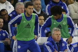 Chelsea's manager until the end of the season Guus Hiddink, center bottom, watches as substitutes Eden Hazard, left, and Loic Remy get up to warm up during the English Premier League soccer match between Chelsea and Watford at Stamford Bridge stadium in London, Saturday, Dec. 26, 2015. (AP Photo/Matt Dunham)